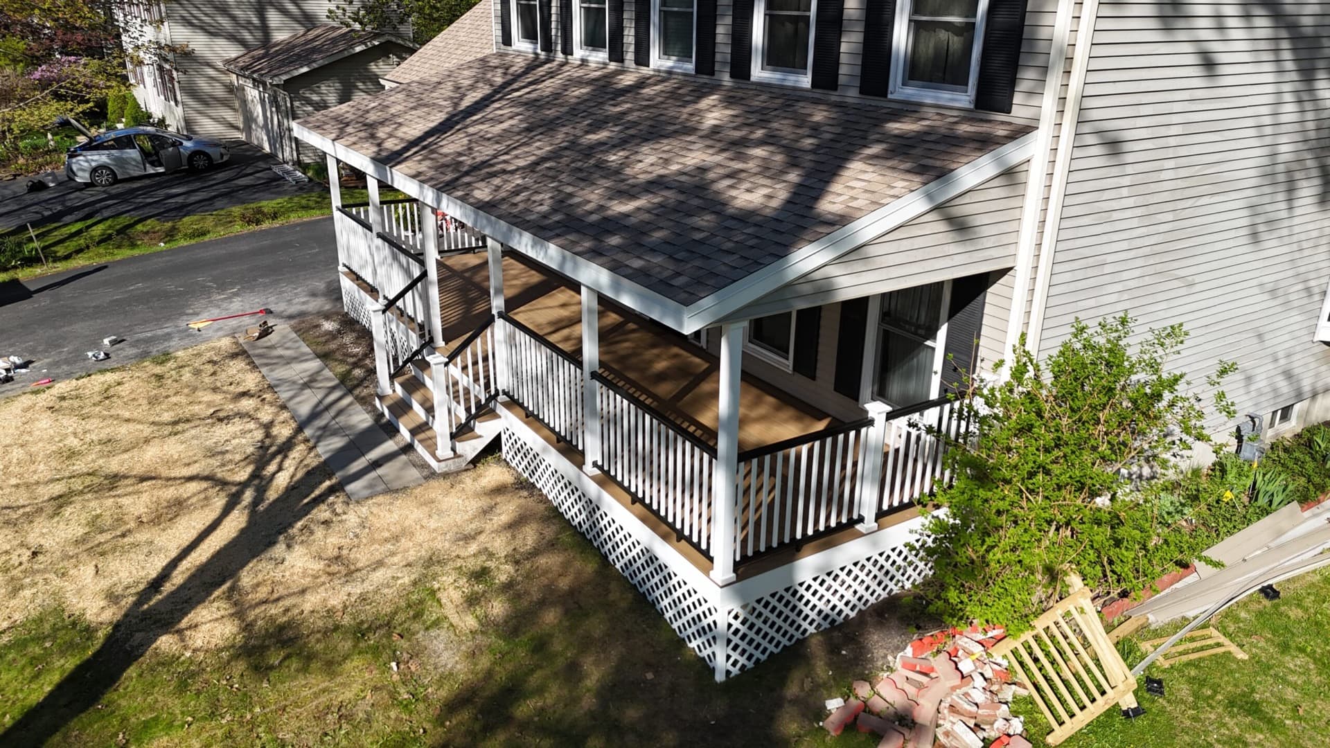Drone view of a custom covered porch with new architectural shingle roof in Chittenden County