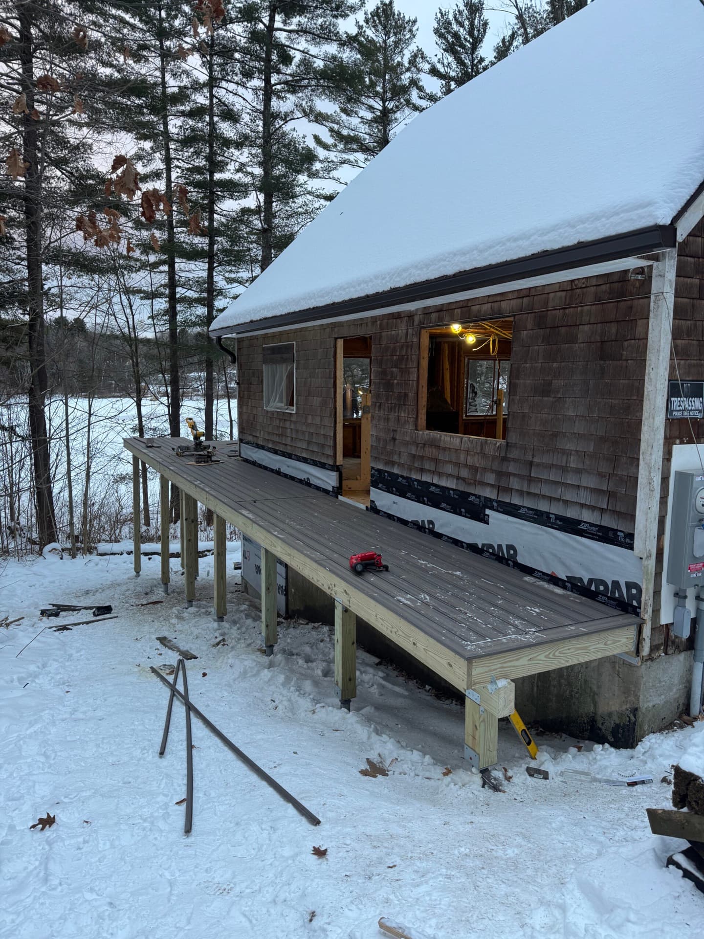 Winter deck build with helical footings on a Vermont camp